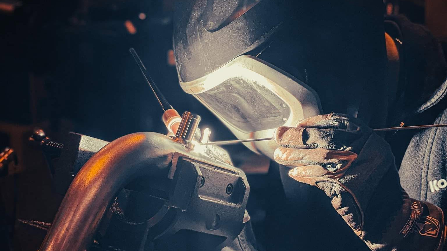 Person welding a metal object in a workshop setting
